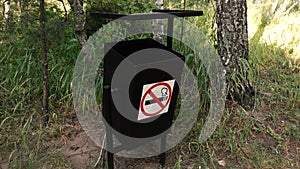 A non-Smoking sign hung on a black urn