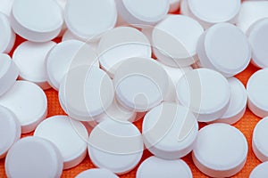 Non-steroidal anti-inflammatory drugs. Acetaminophen white tablets on orange