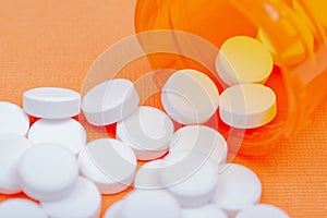 Non-steroidal anti-inflammatory drugs. Acetaminophen white tablets on orange photo