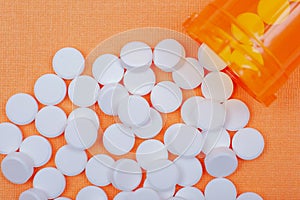 Non-steroidal anti-inflammatory drugs. Acetaminophen white tablets on orange photo