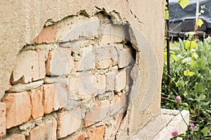 Non technology plaster. Building cracked plaster facade wall with brick