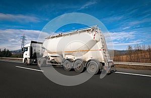 Non-Tipping silo semitrailer carrying chemical material on the highway. Truck, Tanker Chemical Delivery.