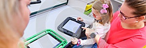 Non-verbal girl living with cerebral palsy, learning to use digital tablet device to communicate.