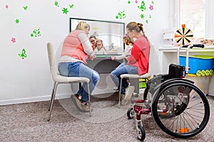 Non-verbal girl living with cerebral palsy, learning to use digital tablet device to communicate. photo