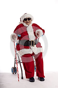 A nonagenarian in a Santa Claus costume sitting on a walker with a white background.