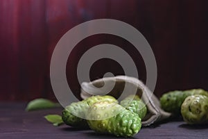 Noni fruit and leaves on wooden table,Top view