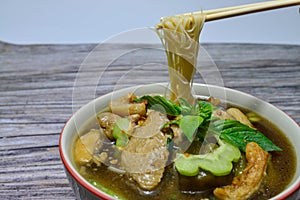 Noodle with chicken in bowl and chopsticks  on wood background with clipping path. Tasty noodle.