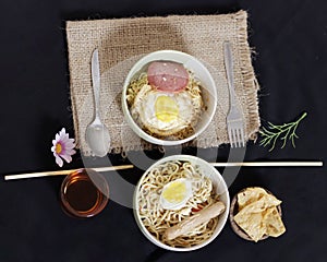 Noodle dumplings in a bowl with beef, egg and sausage toppings.