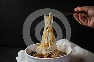 Noodle with Kao Lao Moo Toon. Thai pork stew soup in white bowl on black table. photo