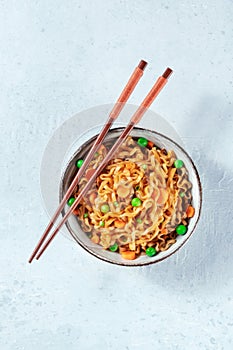 Noodles bowl with chopsticks, top shot