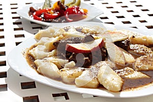 Noodles and game meat stew with lot of sauce on white plate