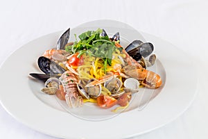 Noodles with mussels and shrimp on white dish background