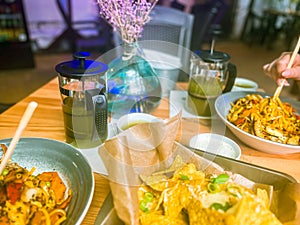 Noodles, nachos and tortilla chips on a table in a restaurant