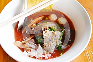 Noodles with seafood on red soup - hot and spicy thai food noodle squid pork fish ball morning glory crispy wonton skin pork and