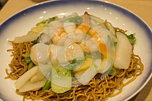 Noodles topped with paste and shrimps, scallops, vegetables