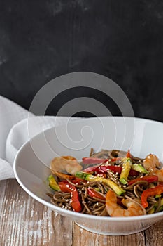 Noodles with vegetables and seafood on a wooden table Chinese-style noodles with vegetables and seafood. copy space.