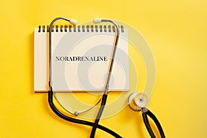 NORADRENALINE - next to a stethoscope on a yellow warm background