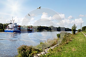Nord-Ostsee-Kanal with cargo ship and seagulls near Rendsburg, Germany
