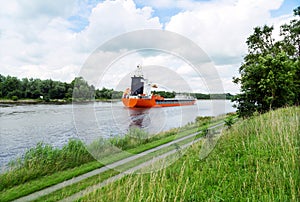 Nord-Ostsee-Kanal with red vessel ship near Rendsburg, Germany