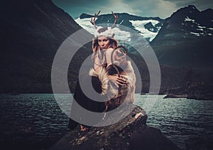 Nordic goddess in ritual garment near wild mountain lake in Innerdalen valley.