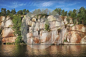 nordic rocky shore, trees on cliffs. Gulf of Finland, Vyborg bay, Monrepos park