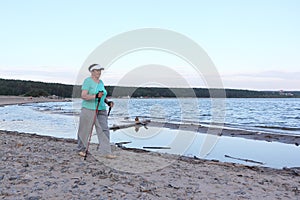 Nordic Walking - elderly woman is hiking along the river