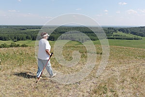 Nordic Walking - elderly woman is hiking in summer