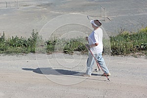 Nordic Walking - elderly woman is hiking in the summer