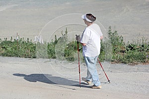 Nordic Walking - elderly woman is hiking in the summer