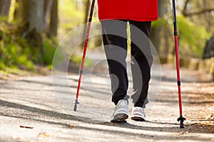 Nordic walking. Female legs hiking in the park.