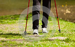 Nordic walking. Female legs hiking in the park.