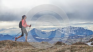 A Nordic walking girl walking alone in the mountains