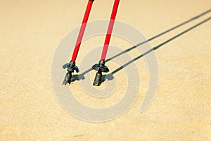 Nordic walking. Red sticks on the sandy beach