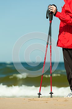 Nordic walking. Red sticks on the sandy beach