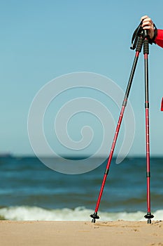 Nordic walking. Red sticks on the sandy beach