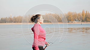 Nordic Walking. Side follow shot of motivated chubby girl doing walking exercise as a park of weight loss program