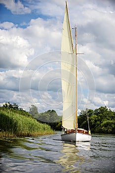 Norfolk Broads sail boat sailing on a river