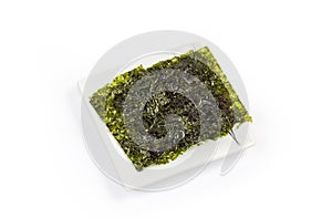 Nori seaweed snack on square white dish on white background