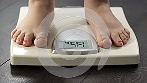 Normal healthy body weight, woman standing on scales to measure dieting results