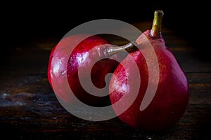 Normal view of a red pear or red battler on the table. Dark background. Organic and natural products, healthy and wholesome food