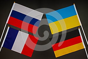 Normandy four meeting. Normandy format summit. Flags of Ukraine, Russia, Germany, France on black background. War in Donbas. photo