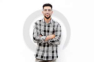 North African man smiling against white background with arms crossed