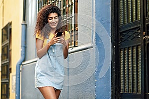 North African woman walking on the street looking at her smart phone