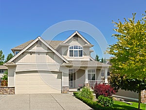 North american family house with concrete driveway to the garage on blue sky background