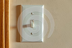 An North American light switch on a wall near a doorway