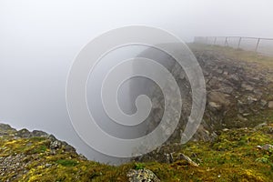 North Cape Nordkapp, on the northern coast of the island of Mageroya in Finnmark, Northern Norway on heavy foggy day .