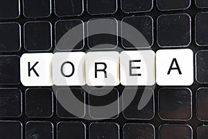 North Korea control text word title caption label cover backdrop background. Alphabet letter toy blocks on black reflective backgr