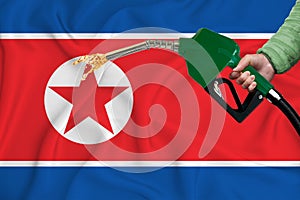 NORTH KOREA flag Close-up shot on waving background texture with Fuel pump nozzle in hand. The concept of design solutions. 3d