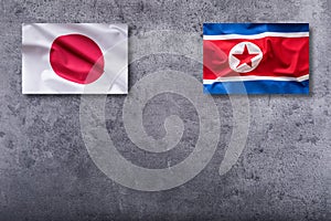 North Korea and Japan flags. North Korea and Japan flag on concrete background
