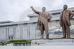North Korean people bowing in front of Kim Il Sung and Kim Jong Il statues in Mansudae Grand Monument, Pyongyang, North Korea